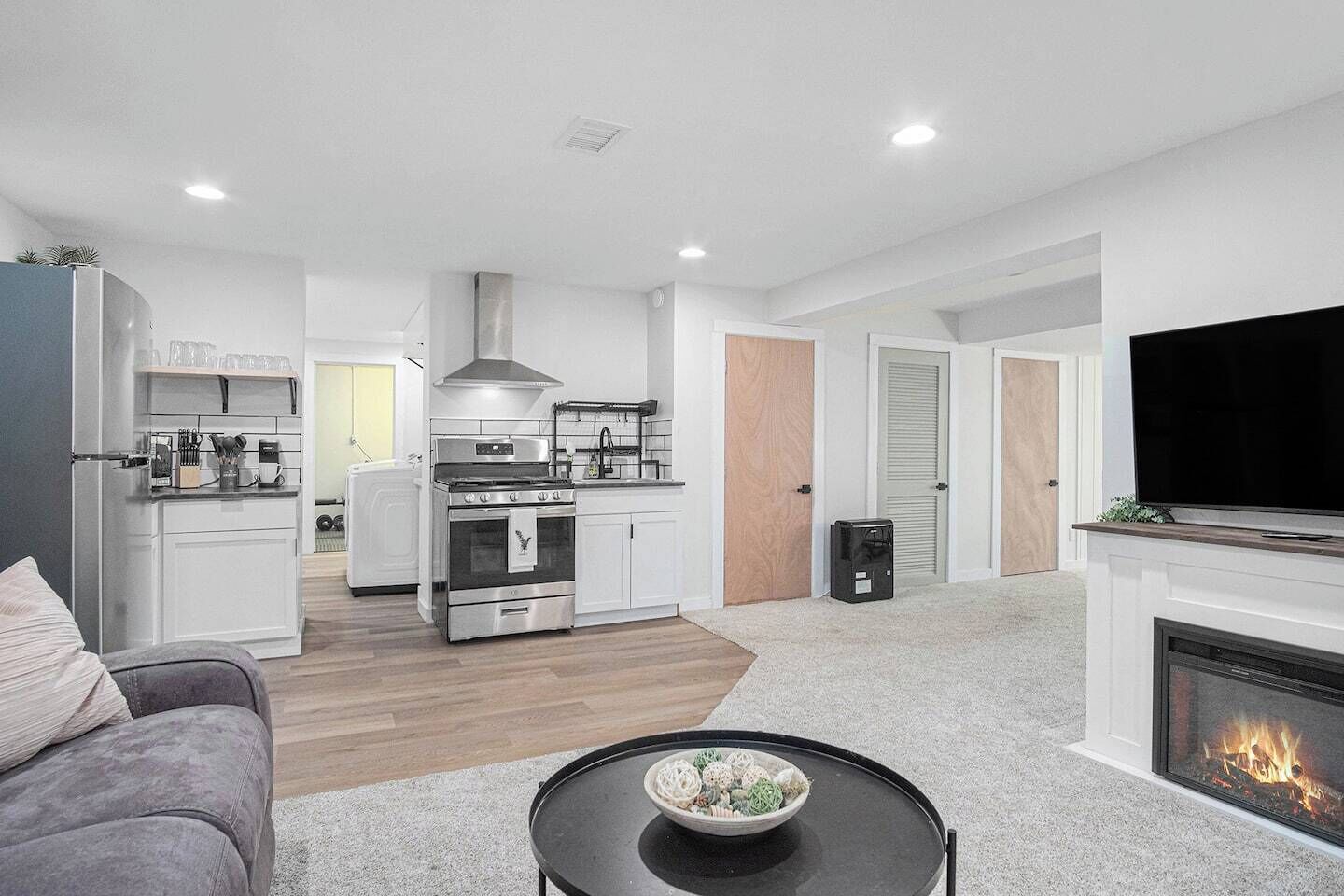 Full kitchen equipped with stovetop pots and pans, measuring cups, silverware, essential cooking utensils, cutting board, plates, bowls, cups, and mixing bowls, coffee maker, microwave —everything you need for preparing and enjoying meals.