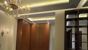 Ein Schlafzimmer mit Bett, Kleiderschrank, einer Kronleuchter und einer Holzwand.