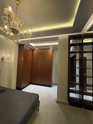 Un dormitorio con cama, armario, candelabro y una partición de madera.