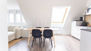 Una cocina moderna con una mesa de comedor, sillas y horno empotrado.