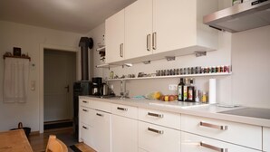 Una cocina moderna con armarios blancos, electrodomésticos de acero inoxidable y una amplia variedad de utensilios de cocina.