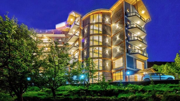 Ein mehrstöckiges Hotel mit Balkonen, großen Fenstern und einer gut beleuchteten Fassade.
