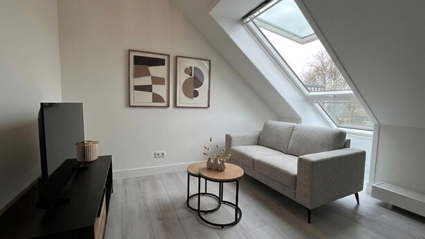 A modern living room with a sofa, a coffee table, and artwork on the wall.