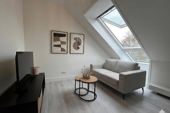 A modern living room with a sofa, a coffee table, and artwork on the wall.