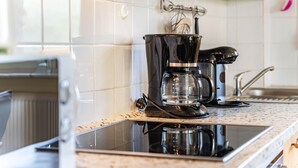 Eine Küche mit Kaffeemaschine, Wasserkocher und Spüle.