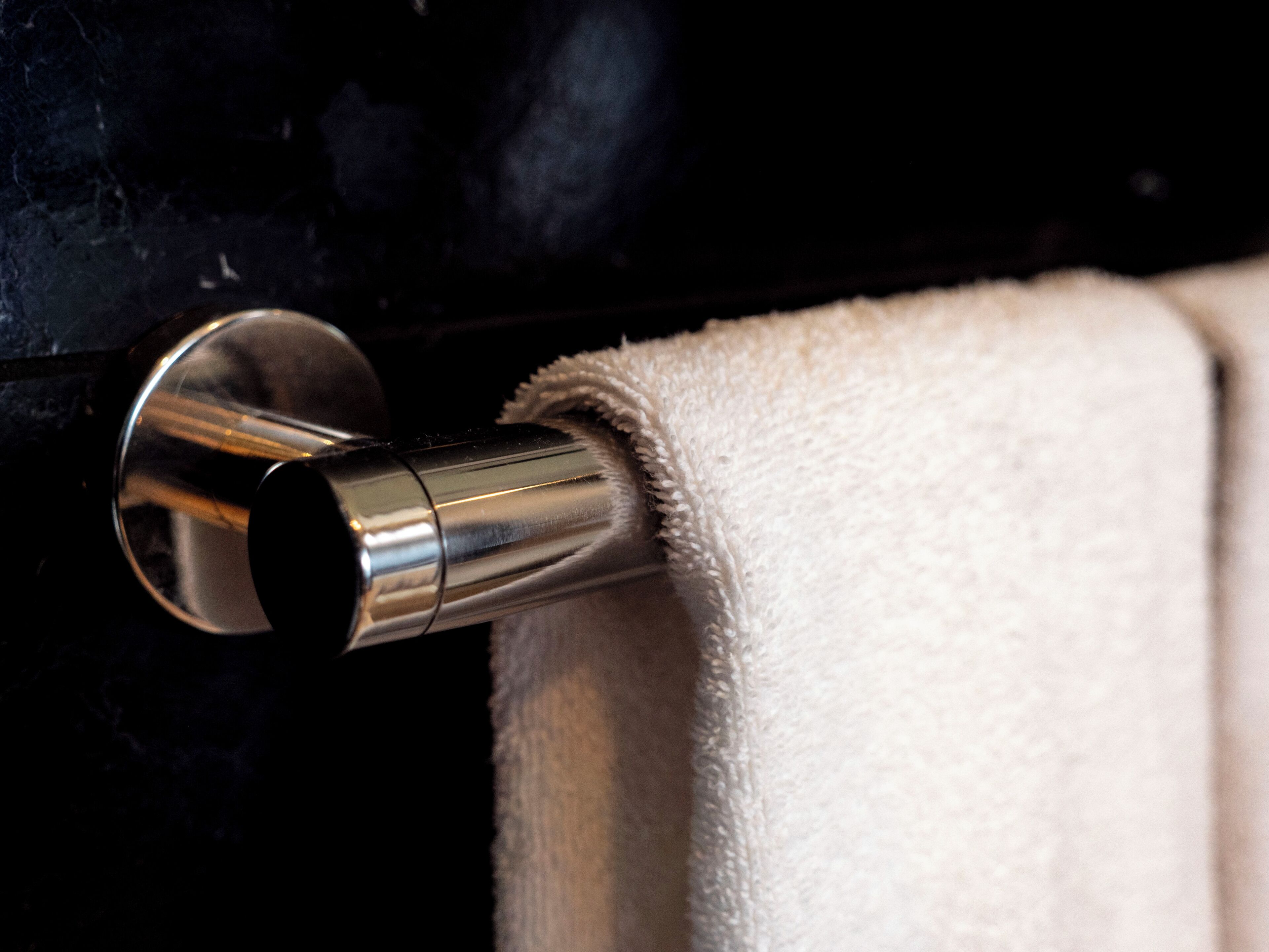 A metallic towel holder with a white towel.
