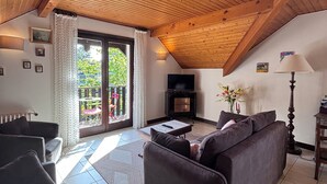 Un salon confortable avec un canapé, un téléviseur et une cheminée.