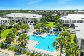 Ein Resort mit einem zentralen Pool, mehreren Gästezimmern und einem gepflegten Rasen.