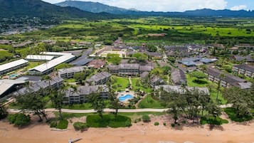 An aerial view of a resort with multiple buildings, a swimming pool, and a beach.