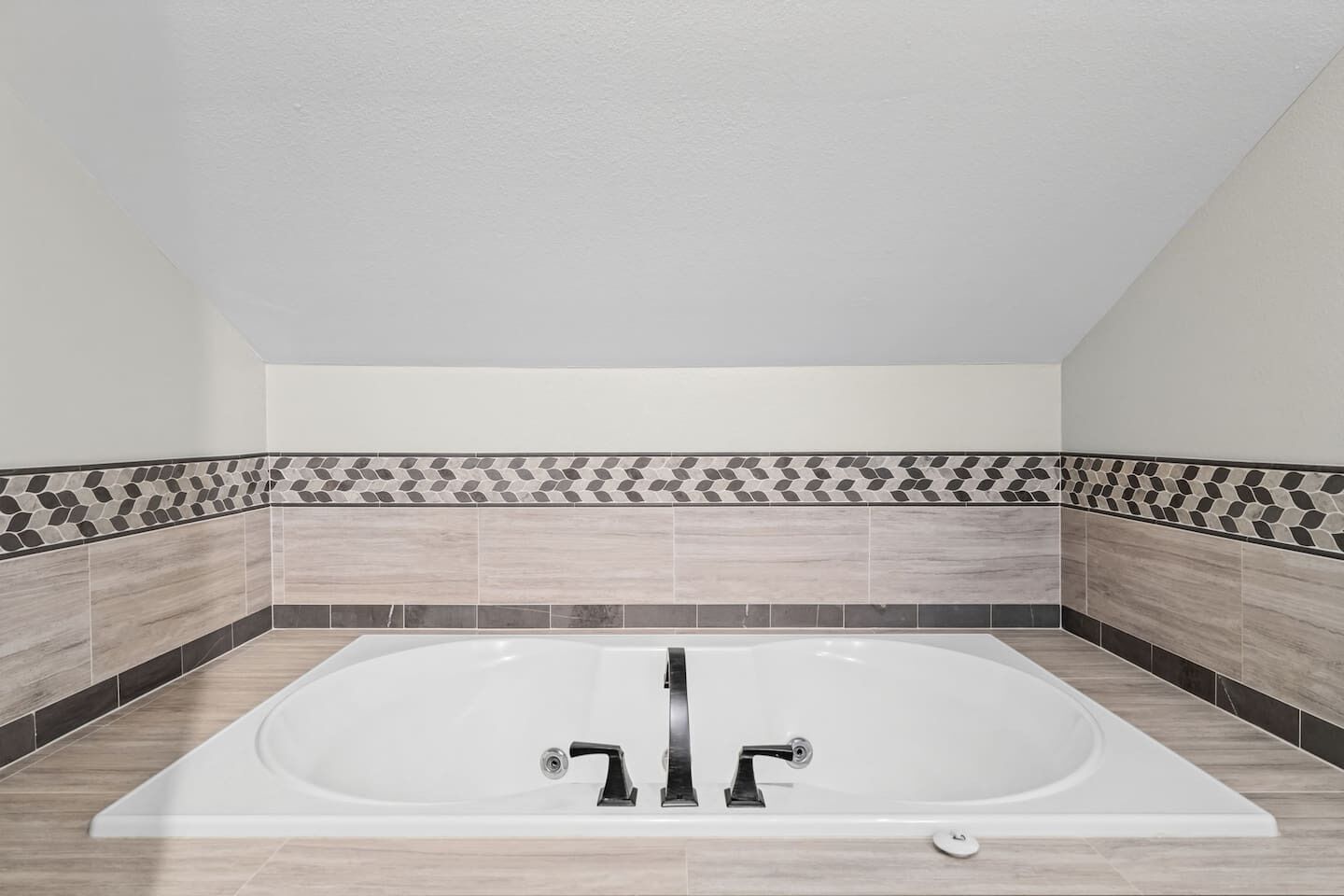 A modern bathroom with a freestanding bathtub, tiled walls, and a neutral color scheme.