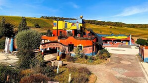 A colorful building with a sign reading 'WEINPARADISES' in a rural setting.
