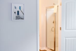 A white door with a glass panel, a white wall, and a framed picture of a blue door and stairs. - 3-bedroom house in serene Pooler with cool AC breeze (Pooler)