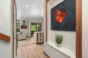 Ein Flur mit modernem Interieur, einem Sofa, einem kleinen Tisch und einem Blumentopf.