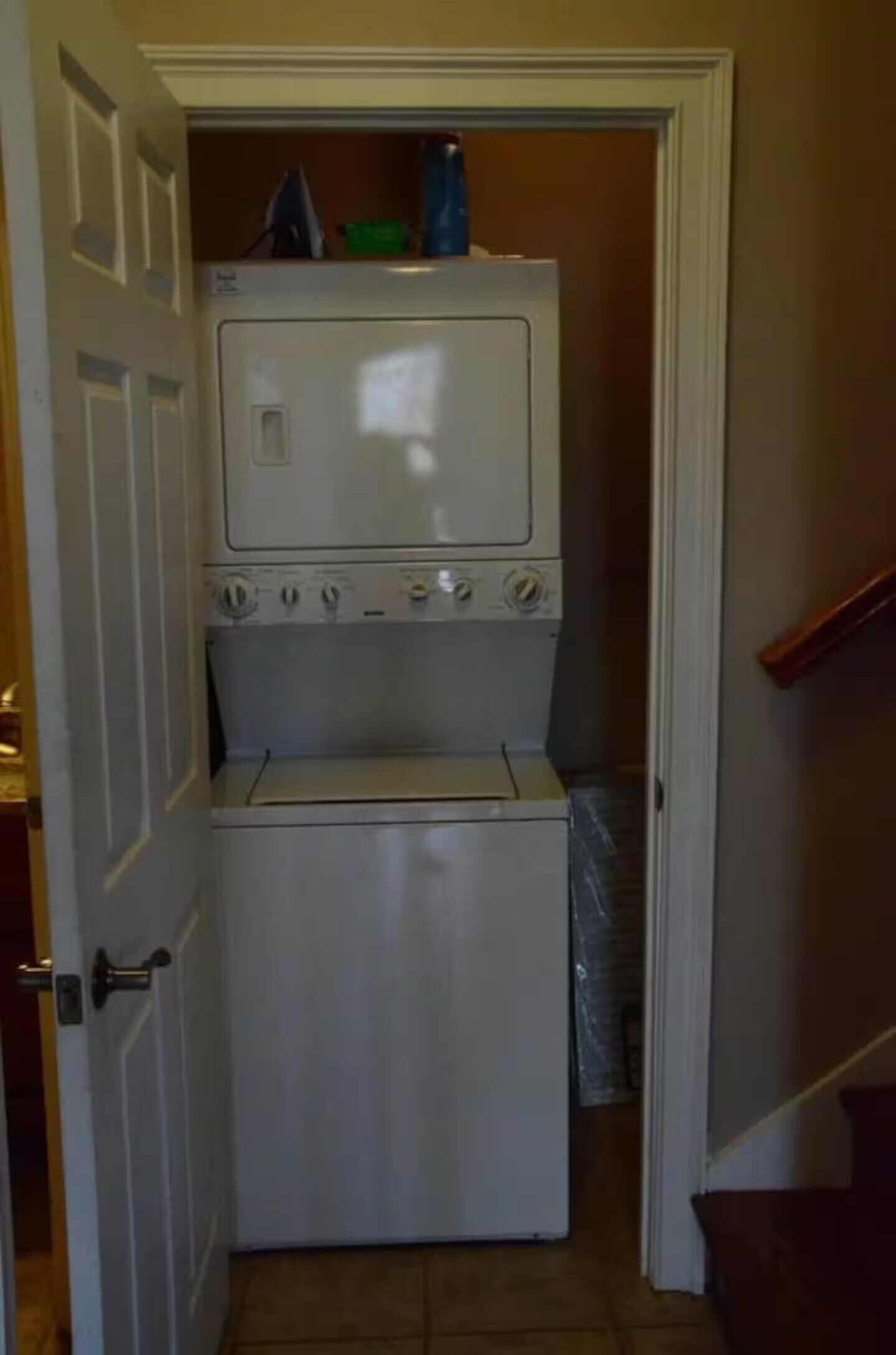 Une buanderie équipée d’un lave-linge et d’un sèche-linge, avec une porte et un escalier.