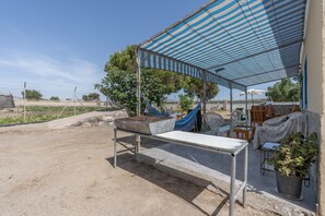 Un espacio al aire libre techado con mesa, sillas y una planta en maceta.