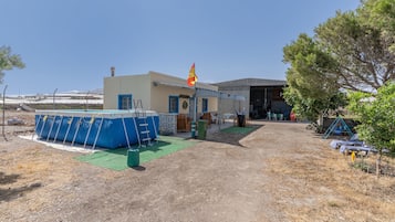 Een gebouw met een zwembad, een vlag en een overdekt terras.