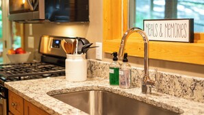 Una cocina con encimeras de granito, electrodomésticos de acero inoxidable y un cartel que dice 'Meals & Memories'.