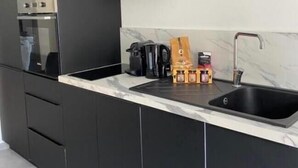 A modern kitchen with a built-in oven, a coffee maker, and a sink. - Ground-floor apartment in a quiet residence (Corte)
