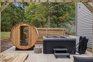 Eine Holzsauna mit Glastür, einem Whirlpool und einer Sitzbank.