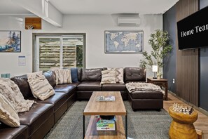 Ein modernes Wohnzimmer mit einer Eckcouch, einem Couchtisch und einer Weltkarte an der Wand.