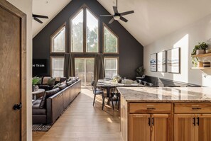 An open layout flows from kitchen to dining to living area, so no one misses a moment while meals are prepared and shared. - Stay & Play | Poconos Lake • Hot Tub • Sauna (Albrightsville)