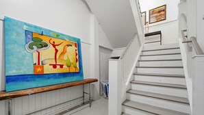 A staircase with white railings and a wooden handrail, leading to an upper floor. - Grenadine Dreams (Gulf Shores)