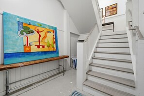 Eine Treppe mit weißen Geländern und einem hölzernen Handlauf, die zu einer oberen Etage führt.