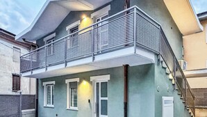 A two-story building with a balcony, a staircase, and a door. -  Casa Cavour - In Val di Susa con Parcheggio Moto (Bruzolo)