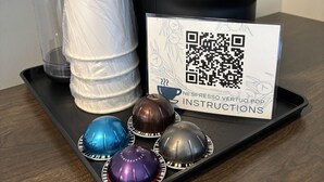 A coffee machine, a stack of cups, and a tray with coffee capsules. - Juniper Motel*King*RM15*Dock*ATV Access*Waterfront*Kayak/Boat Rentals (Greenville)