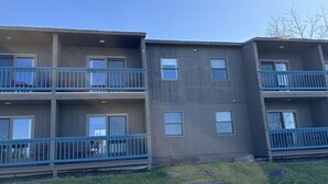A multi-story residential building with balconies, windows, and a grassy area in front. - Juniper Motel*King*RM15*Dock*ATV Access*Waterfront*Kayak/Boat Rentals (Greenville)