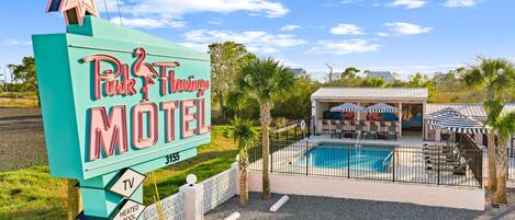 Un panneau indiquant un motel proposant les commodités suivantes : télévision, piscine chauffée, climatisation et accès Wi-Fi.