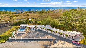 A resort with a pool, outdoor seating, and a view of the ocean. - Georgia Peachy | Orange Boutique Retreat (Port Saint Joe)