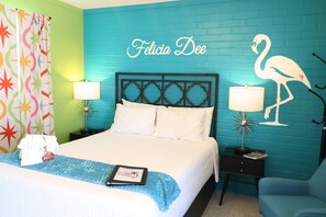 A neatly made bed with white linens, a blue throw blanket, and a framed picture on the bedside table. - Felicia Dee | Pet-Friendly Sea-Inspired Studio (Port Saint Joe)