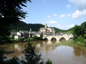 A historic town with a castle, a river, and a bridge.