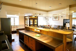 A spacious kitchen with a central island, wooden cabinets, and pendant lighting.
