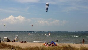 A beach with people, a kite, and a boat. - Country house Wendy 1 semi-detached house 250 m² 6 bedrooms, 4 bathrooms, garden (Gägelow)