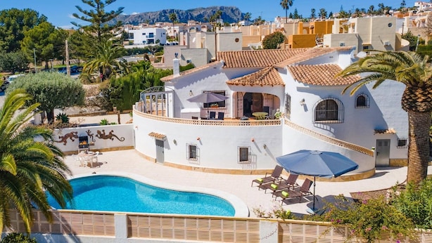 A white villa with a swimming pool, outdoor seating, and a view of the surrounding neighborhood. - Villa Papillon by Villa Plus (Calp)