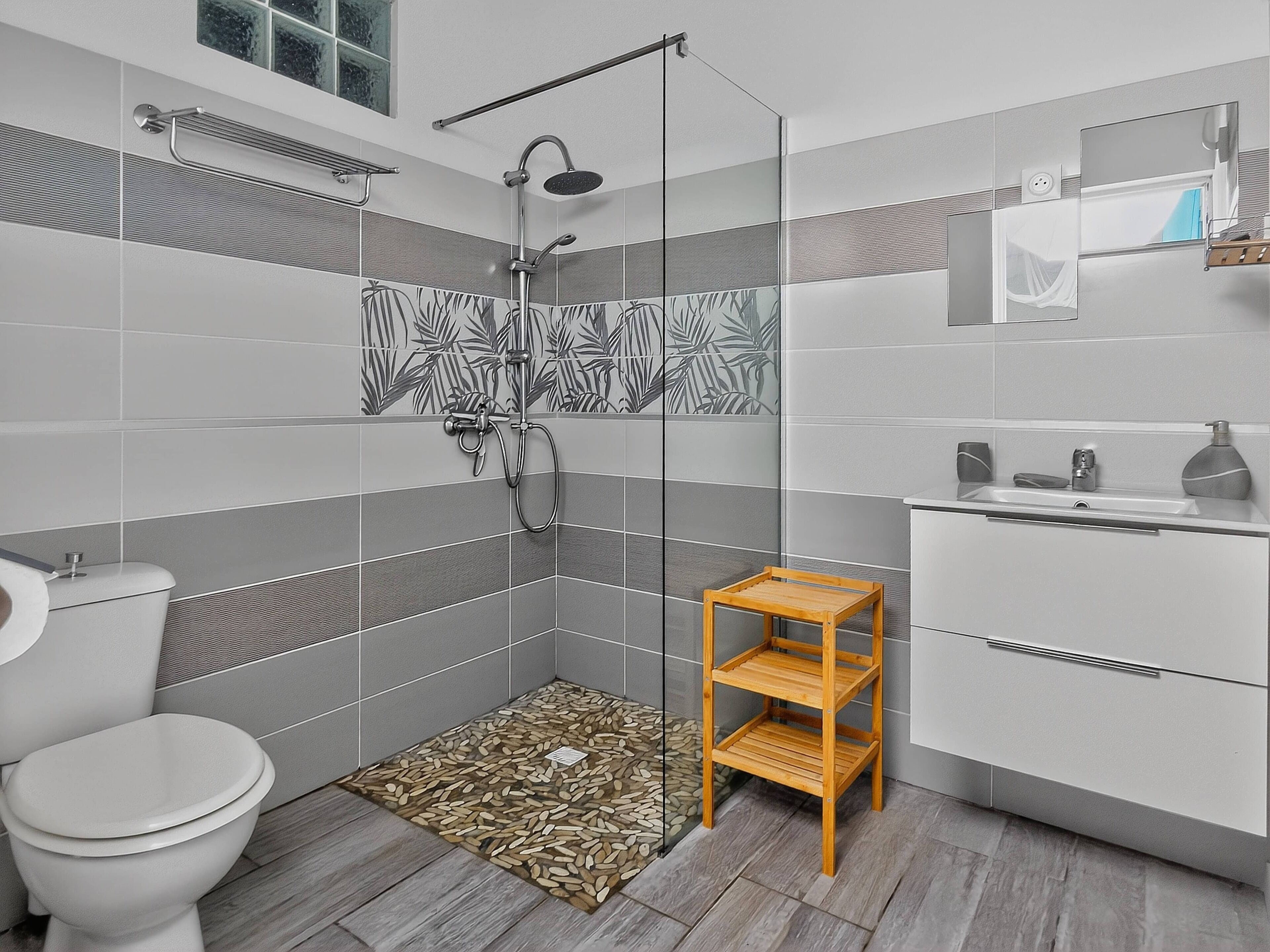 Un baño moderno con ducha, inodoro y tocador.