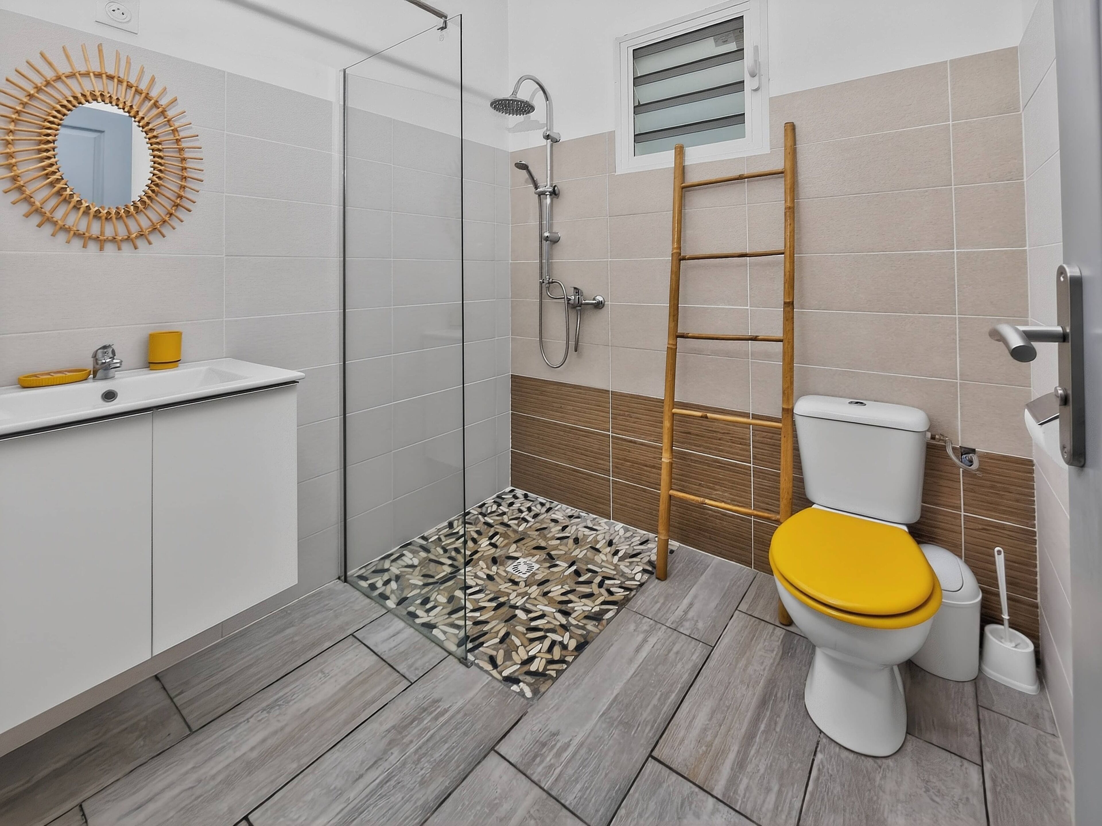 A bathroom with a shower, toilet, sink, and a mirror.