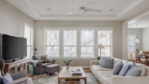 A living room with a television, sofas, a coffee table, and a ceiling fan. - SoCo Craftsman ~ Walk to Shops, Cafés, Parks (Austin)