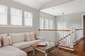 Ein Wohnzimmer mit einer Couch, einem Couchtisch und einer Treppe.