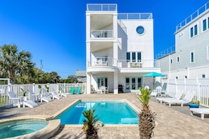 A two-story building with a swimming pool, outdoor seating, and a white fence. - Endless Views (St. Augustine)