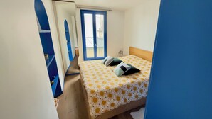 Ein Schlafzimmer mit Bett, Fenster und Tür.