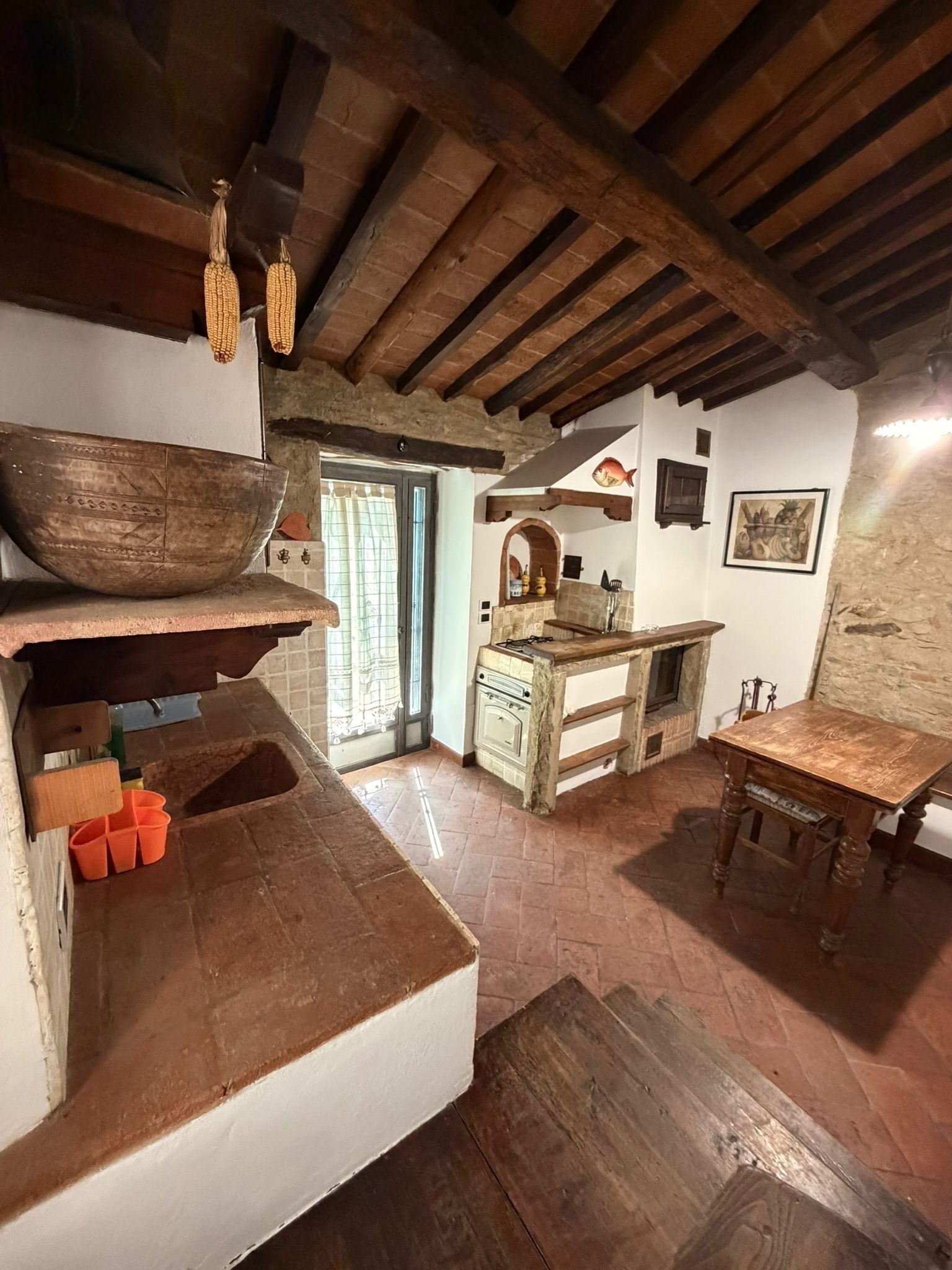 Une cuisine rustique avec un grand saladier en bois, un évier et une table en bois.