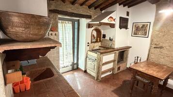 Une cuisine rustique avec un grand saladier en bois, un évier et une table en bois.