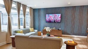 Un salon moderne avec un canapé, un téléviseur et une plante décorative.