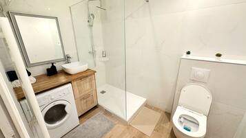 Apartamento Deluxe, vistas a la ciudad | Baño | Ducha, artículos de higiene personal gratuitos, toallas y jabón