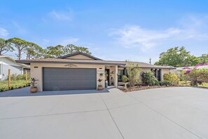 A residential house with a garage, a driveway, and landscaping.