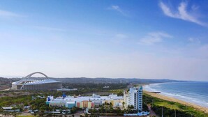 A coastal hotel with a modern stadium, beachfront, and a mix of residential and commercial buildings. - Hilton Durban (Durban)