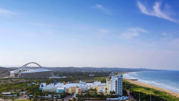 A coastal hotel with a modern stadium, beachfront, and a mix of residential and commercial buildings. - Hilton Durban (Durban)